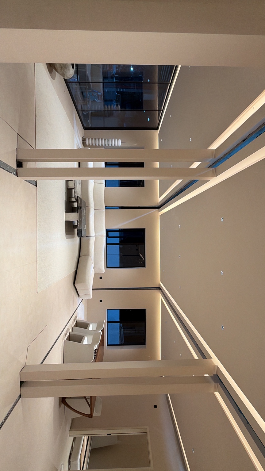 El salón va tomando forma: sofá claro, comedor e iluminación cálida.